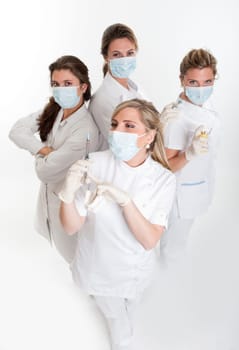 Four female dentists posing with masks and equipment