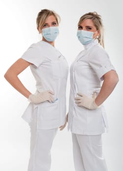 Two young female dentists posing with uniform and mask