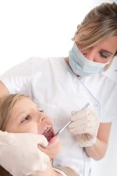 Dentist inspecting the teeth of a young girl