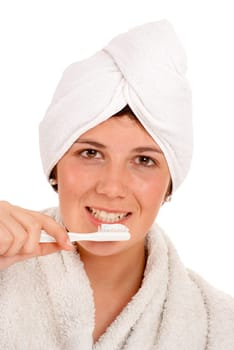Isolated image of a cute girl with a towel around her head brushing her teeth