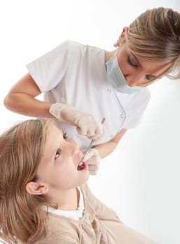 Dentist inspecting the teeth of a young girl