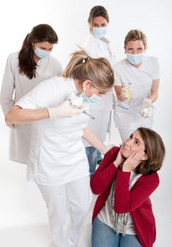 A woman on her knees surrounded by an aggressive group of female dentists