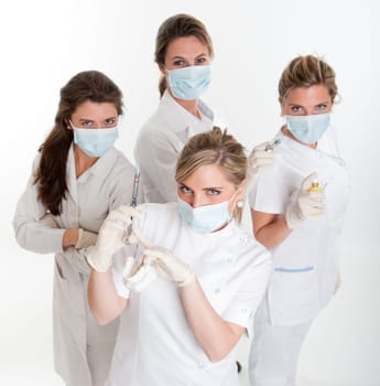 Four female dentists posing with masks and equipment