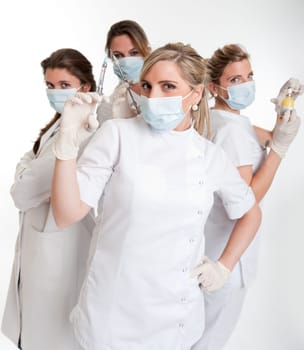 Four female dentists posing with masks and equipment