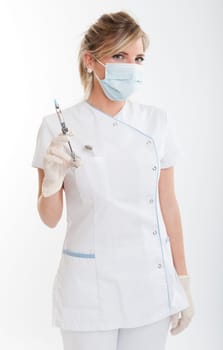 Attractive blonde female dentist holding a syringe