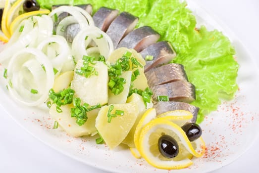 Herring with potato and vegetables isolated on a white background