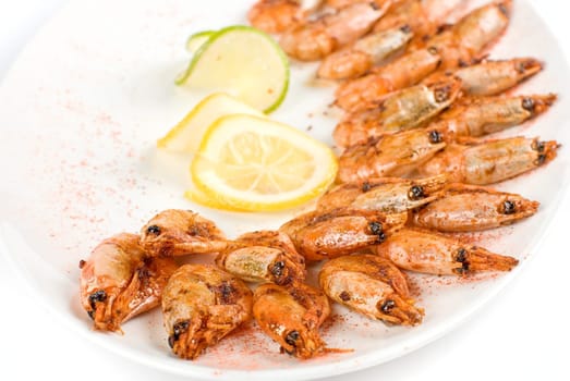 roasted shrimps with lemon closeup isolated on a white background