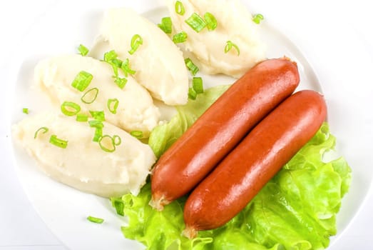 Cutlets from potato and sausage at green lettuce and green onion