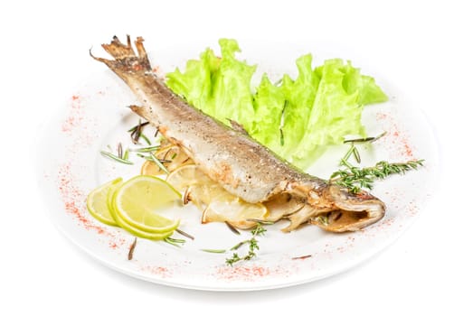 fish with lemon and greens on white background