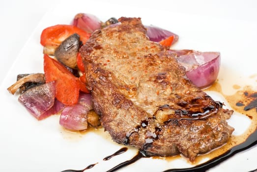 Roasted beef steak with vegetable closeup at plate