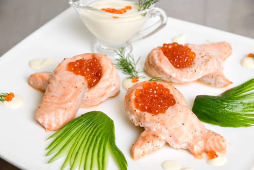 roasted salmon filet with red caviar, cucumbers and sauce
