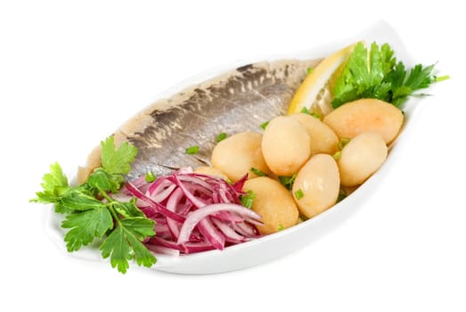 Herring with potato and vegetables isolated on a white background