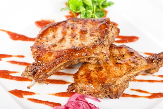 Roasted pork meat at plate with greens