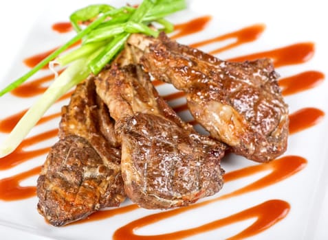 Roasted lamb meat tied with scallion closeup