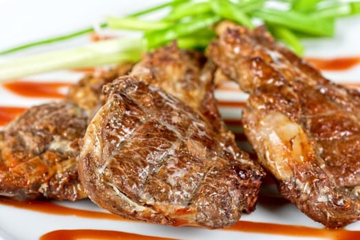 Roasted lamb meat tied with scallion closeup