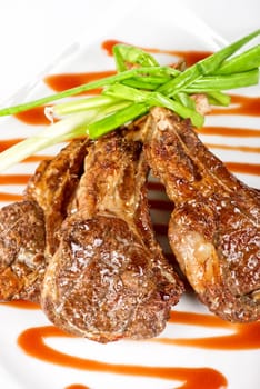 Roasted lamb meat tied with scallion closeup