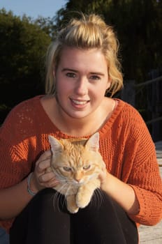 Ginger Cat sitting on Girls Lap