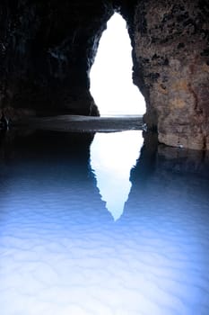 a view from the inside of a beach cave looking out at the sea
