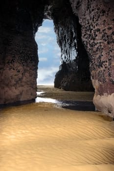 a view from the inside of a beach cave looking out at the sea