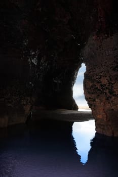 a view from the inside of a beach cave looking out at the sea