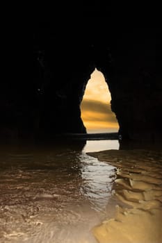 a view from the inside of a beach cave looking out at the sea