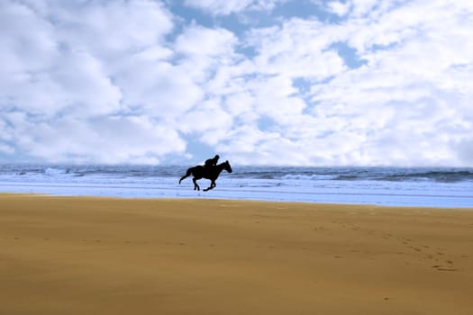 horse riding on ballybunions beach shore on irelands west coast