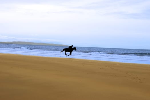 horse riding on ballybunions beach shore on irelands west coast