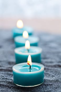 Close-up of blue candles on silver sand