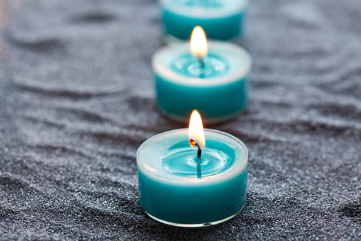 Close-up of blue candles on silver sand