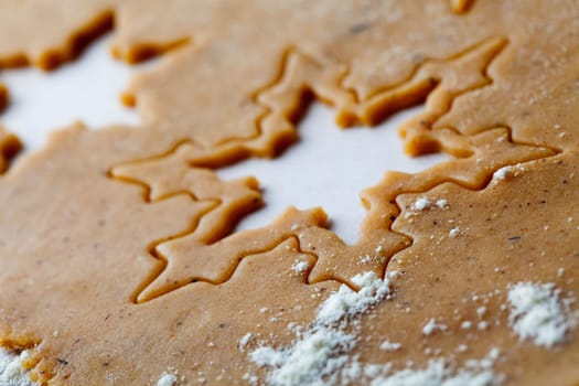 Making gingerbread cookies for Christmas. Gingerbread dough with star shapes.