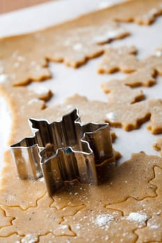 Making gingerbread cookies for Christmas. Gingerbread dough with star shapes and a cutter.