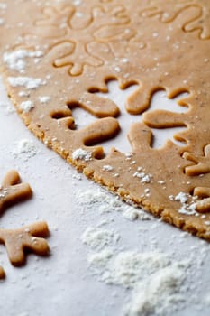 Making gingerbread cookies for Christmas. Gingerbread dough with snowflake shapes.