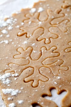 Making gingerbread cookies for Christmas. Gingerbread dough with snowflake shapes.