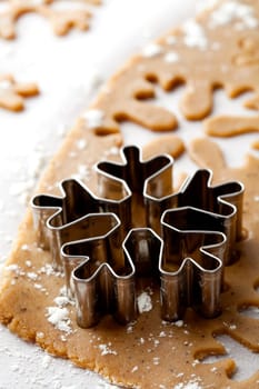 Making gingerbread cookies for Christmas. Gingerbread dough with snowflake shapes.