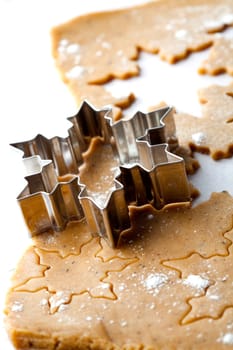 Making gingerbread cookies for Christmas. Gingerbread dough with star shapes and a cutter.