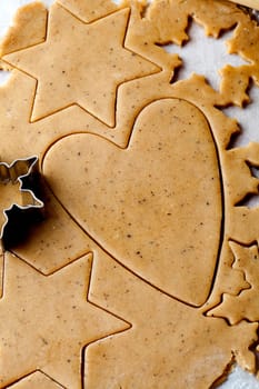 Making gingerbread cookies for Christmas. Gingerbread dough with star shapes and a heart.