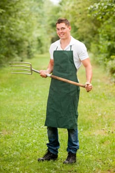 Young gardener with a compost fork
