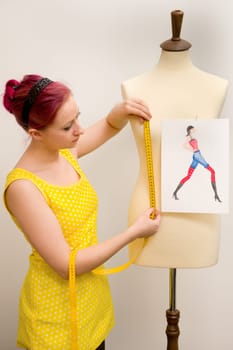 The young seamstress takes measurements of a group of tailors