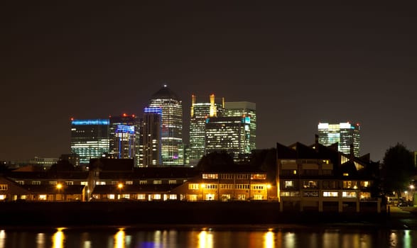 City skyscrapers behind residential houses at night