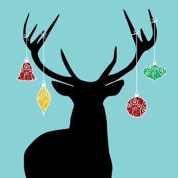 Christmas reindeer silhouette with decorations hanged from its antlers.