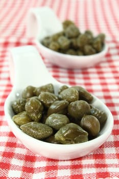 pickled capers on a white spoon
