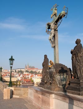 Statue of Jesus on Charles Bridge - Prague Castle in Background, Czech Republic