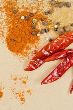dried peppers and other kind of peppers spices on a brown background