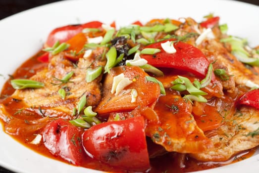 pork meat with tomato, pepper, prunes, garlic and green onion