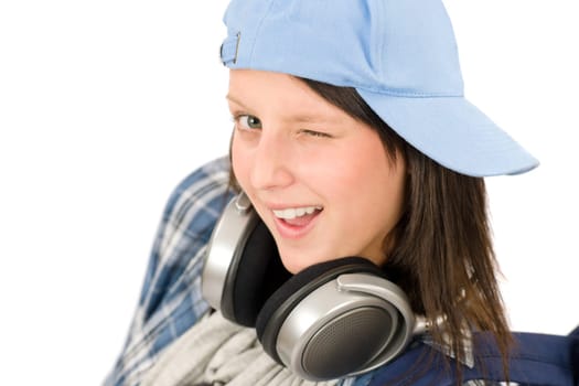 Smiling female teenager enjoy music with headphones and baseball cap