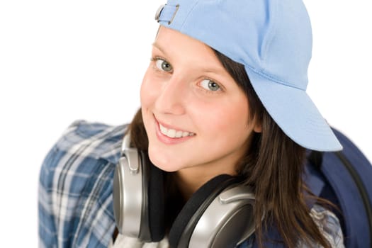 Smiling female teenager enjoy music with headphones and baseball cap