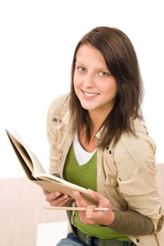 Student teenager girl holding books looking up to camera