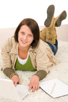 Student teenager happy girl looking laptop lying floor on carpet