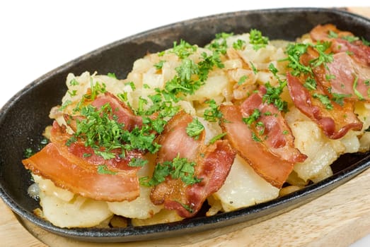 Fried potato with bacon and vegetables on a white