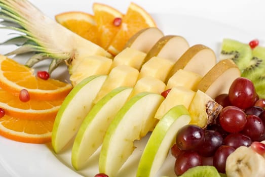 Fruit assortment closeup at plate on a white background